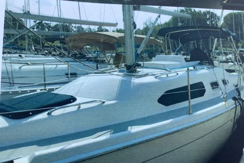 Slide: The Image of Sailboat docked in marina, 2003 Hunter 306 model, surrounded by other vessels. - 9
