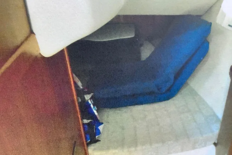 Slide: The Image of Interior cabin of 2003 Hunter 306 sailboat with blue cushions and wooden paneling. - 15