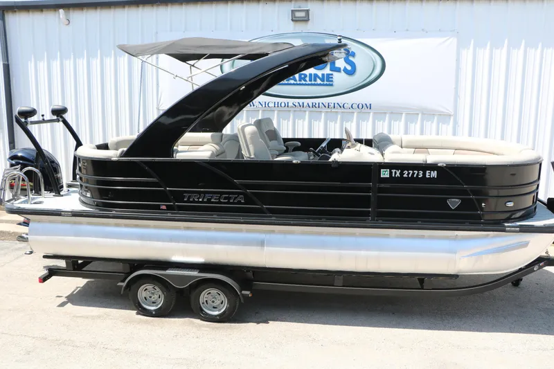 Slide: The Image of 2019 Trifecta 23RF SS Arch pontoon boat with sleek black design on trailer. - 11