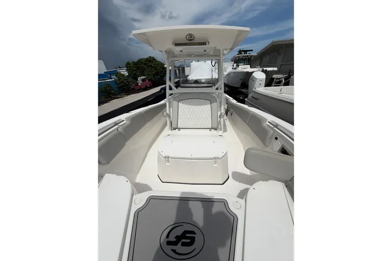 Slide: The Image of 2022 Sea Fox 288 Commander boat interior with seating and storage under a cloudy sky. - 39