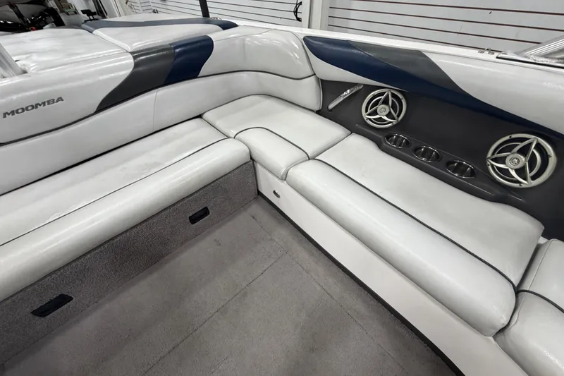 Slide: The Image of 2010 Moomba LSV boat interior with white seating, cup holders, and speakers. - 9