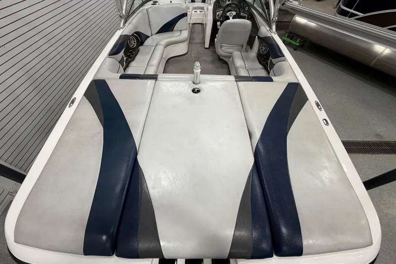 Slide: The Image of 2010 Moomba LSV boat interior with gray and blue seating, steering wheel, and dashboard. - 4