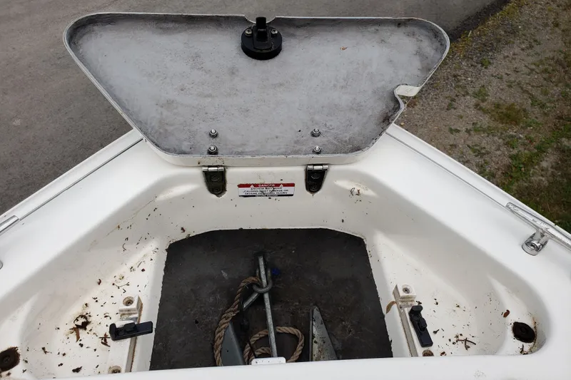 Slide: The Image of Open anchor compartment of 1998 Chaparral 2130 SS boat, showing anchor and rope. - 17