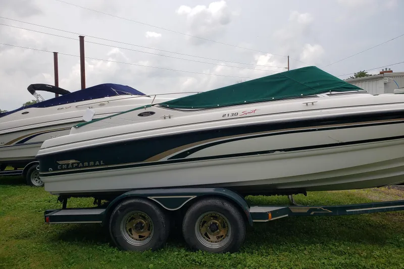 Slide: The Image of 1998 Chaparral 2130 SS boat on trailer with green cover, parked on grass. - 1