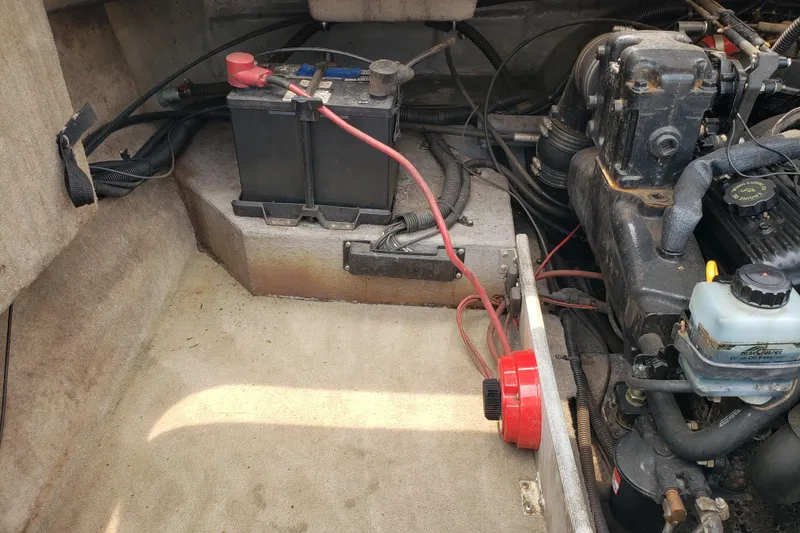 Slide: The Image of Engine compartment of a 1998 Chaparral 2130 SS boat, featuring battery and engine components. - 19