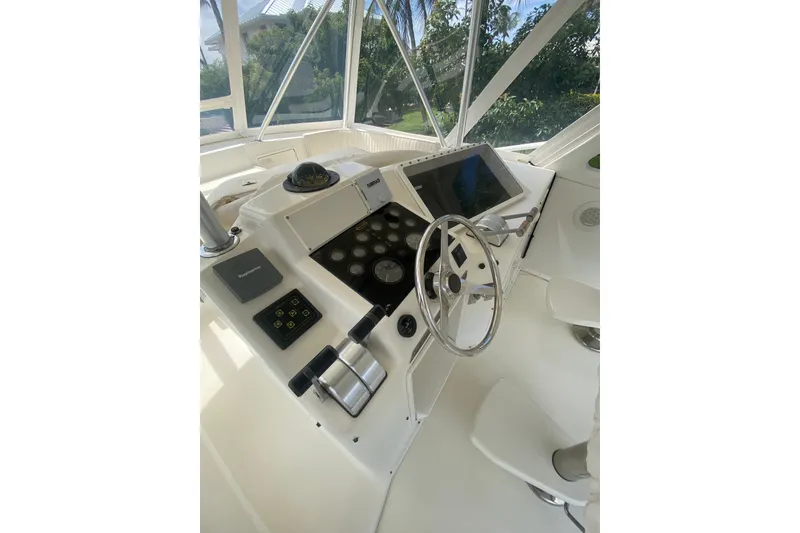Slide: The Image of 1996 Ocean Super Sport boat helm with steering wheel, navigation controls, and display screen. - 4
