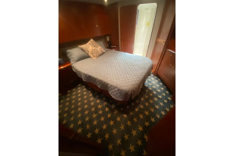 Slide: The Image of Cozy bedroom in 1996 Ocean Super Sport yacht with star-patterned carpet and elegant wood finishes. - 14