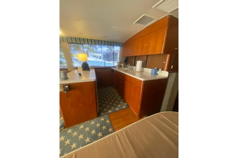 Slide: The Image of Interior of a 1996 Ocean Super Sport yacht with wooden cabinetry and nautical-themed carpet. - 9