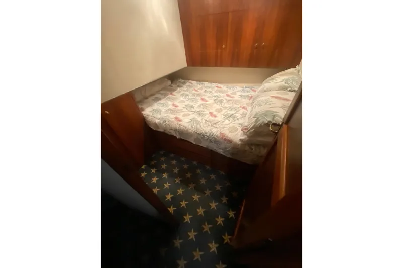 Slide: The Image of Cozy cabin interior of 1996 Ocean Super Sport yacht with floral bedding and star-patterned carpet. - 15