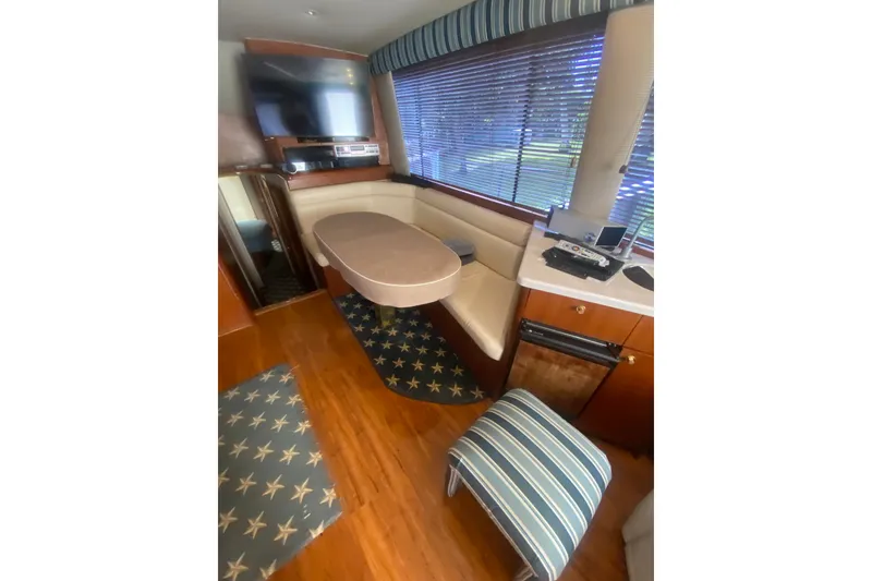Slide: The Image of Interior of a 1996 Ocean Super Sport yacht with dining area and entertainment setup. - 8