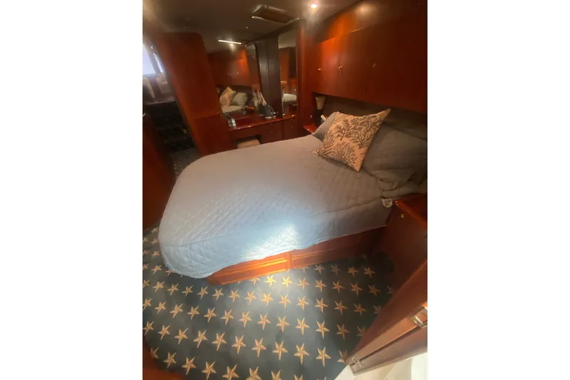 Slide: The Image of Luxurious cabin interior of a 1996 Ocean Super Sport yacht with elegant bedding and wood finishes. - 18