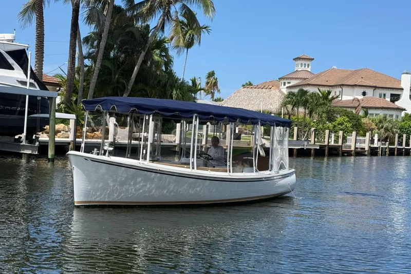 Slide: The Image of 2021 Duffy Bay Island 22 boat cruising on a sunny waterfront with palm trees. - 4