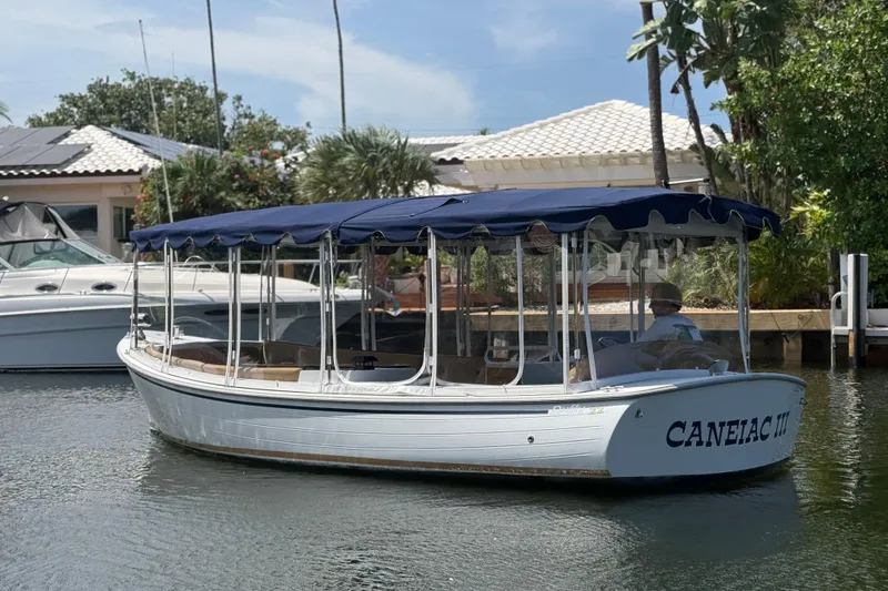 Slide: The Image of 2021 Duffy Bay Island 22 boat with blue canopy on a calm waterway. - 6