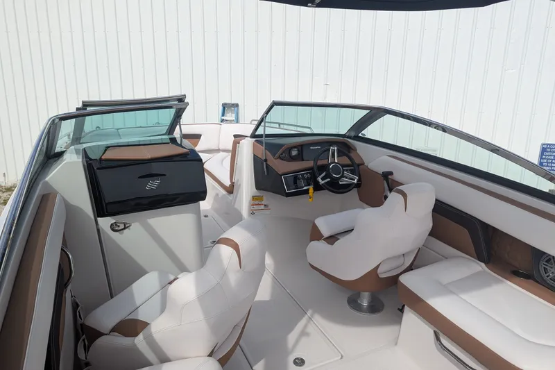 Slide: The Image of 2017 Four Winns HD240 boat interior with white and brown seating, steering wheel, and dashboard. - 13