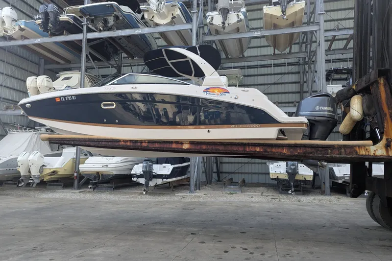 Slide: The Image of 2017 Four Winns HD240 boat on forklift in storage facility. - 2