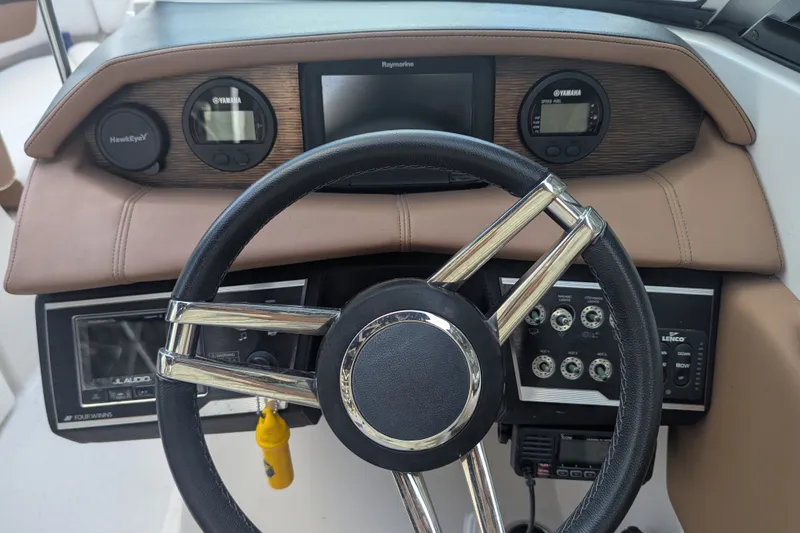 Slide: The Image of Steering wheel and dashboard of 2017 Four Winns HD240 boat with navigation instruments. - 14