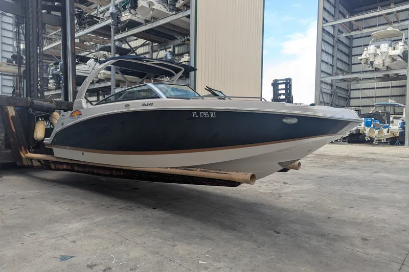 Slide: The Image of 2017 Four Winns HD240 boat in a storage facility, elevated on a forklift. - 3