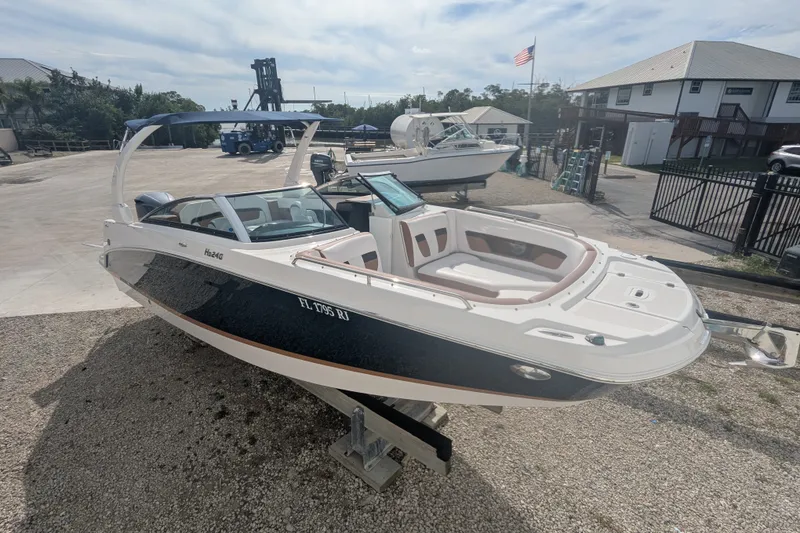 The Image of 2017 Four Winns HD240 boat on display at a marina with American flag. - 1