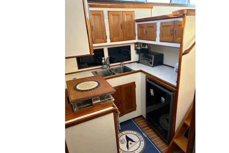Slide: The Image of 1987 Fortier 40 yacht kitchen with wooden cabinets, sink, and appliances. - 13