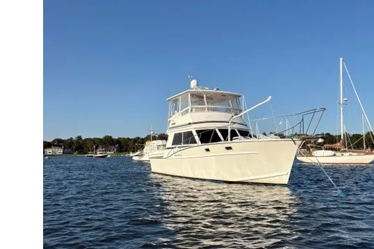 The Image of 1987 Fortier 40 yacht anchored on calm water under clear blue sky. - 0