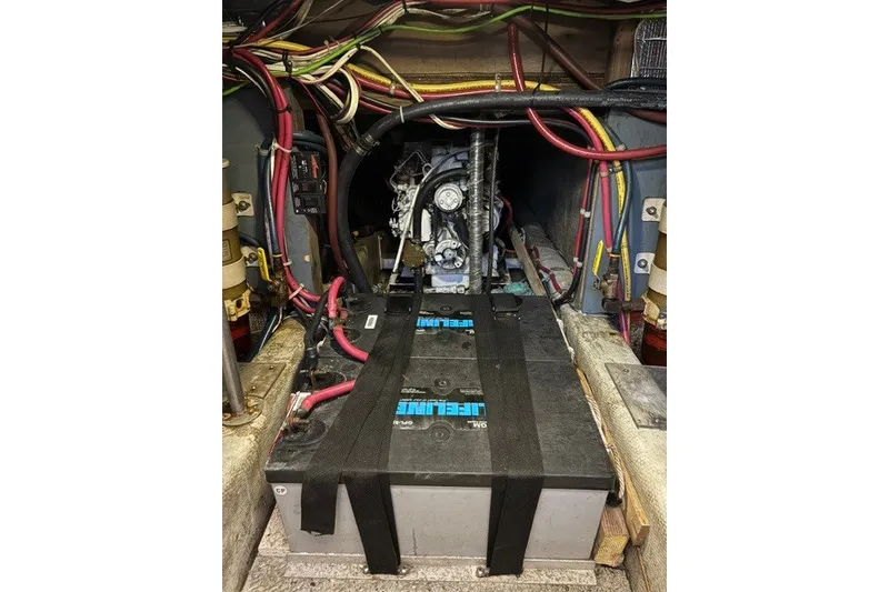 Slide: The Image of Engine compartment of a 1987 Fortier 40 boat, featuring wiring and battery setup. - 20