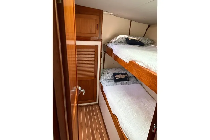 Slide: The Image of Cozy cabin with wooden bunk beds in a 1987 Fortier 40 boat. - 16