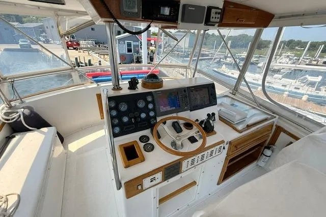 Slide: The Image of 1987 Fortier 40 boat cockpit with navigation instruments and steering wheel at marina. - 7