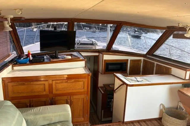 Slide: The Image of Interior of a 1987 Fortier 40 boat with wooden cabinetry and panoramic windows. - 11