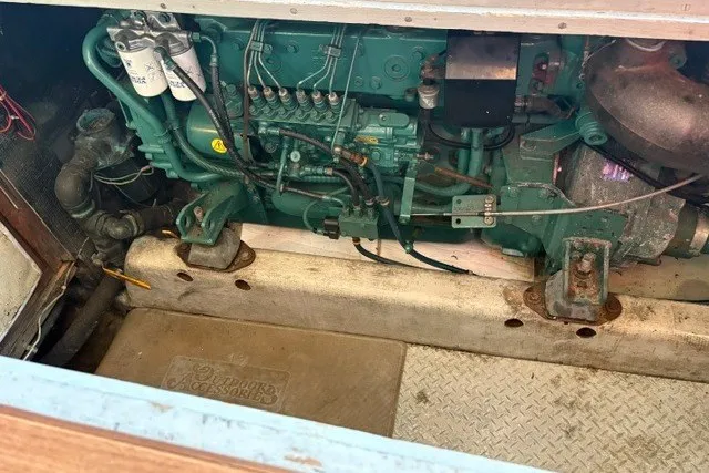 Slide: The Image of Engine compartment of a 1987 Fortier 40 boat, showcasing mechanical components and wiring. - 19