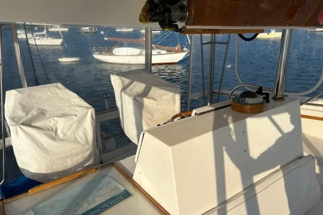 Slide: The Image of Interior view of a 1987 Fortier 40 boat cockpit with covered seats and nautical equipment. - 9
