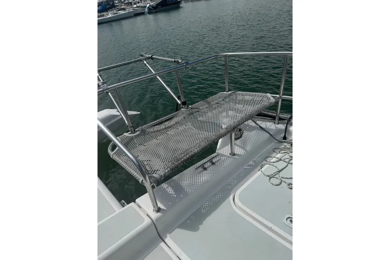 Slide: The Image of 2004 Corsair 36 boat with netted seating on deck, docked by the water. - 11