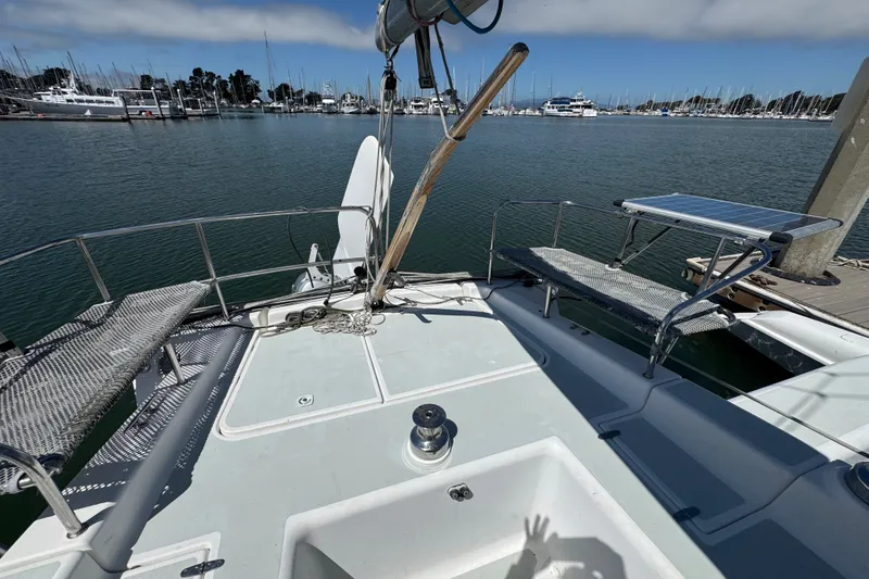 Slide: The Image of 2004 Corsair 36 sailboat deck with marina view, featuring benches and a winch. - 3