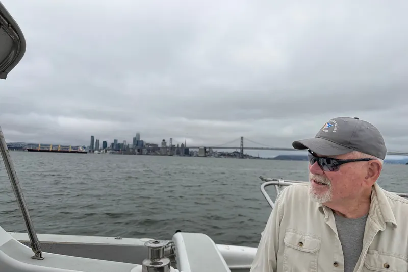 Slide: The Image of Man on a Corsair 36 boat, 2004, with city skyline and bridge in the background. - 15