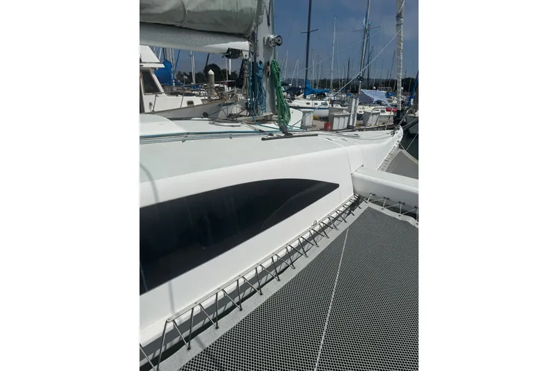 Slide: The Image of Sleek 2004 Corsair 36 sailboat docked at marina, showcasing modern design and netted deck. - 13