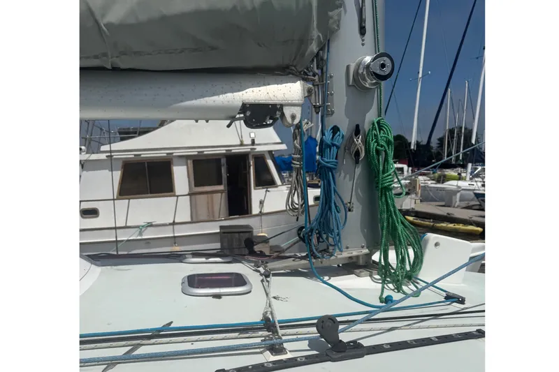 Slide: The Image of A sailboat with ropes and rigging, another boat in the harbor in the background. - 14
