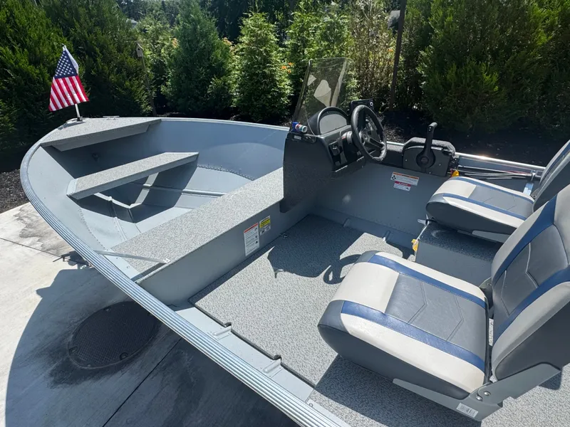 Slide: The Image of A 2025 Lund SSV-18 boat with gray seats and a small helm. A US flag flies at the stern. - 3