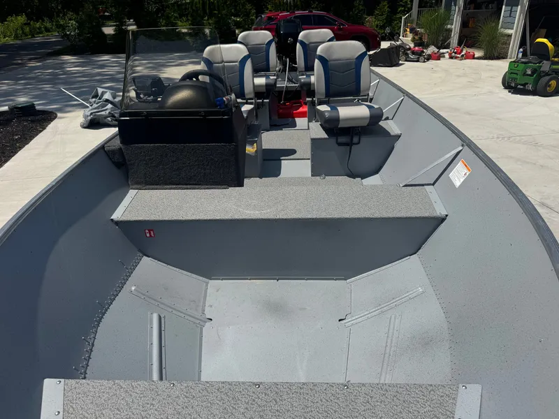 Slide: The Image of The image shows a 2025 Lund SSV-18 boat with a gray interior and blue seats. - 6