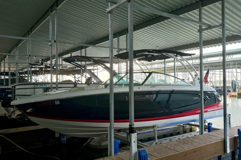 Slide: The Image of 2017 Cobalt A25 boat docked in a covered marina, side view. - 26
