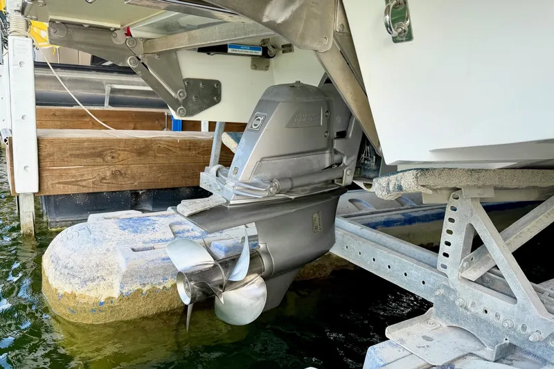 Slide: The Image of 2017 Cobalt A25 boat propeller and stern drive on a lift by the water. - 30