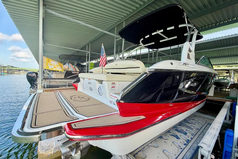 Slide: The Image of 2017 Cobalt A25 boat docked under a covered marina, featuring sleek design and vibrant colors. - 24