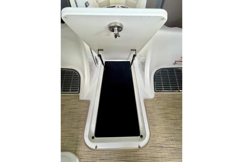 Slide: The Image of Open storage compartment on 2017 Cobalt A25 boat, featuring a secure latch and non-slip flooring. - 38