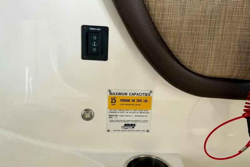 Slide: The Image of 2017 Cobalt A25 boat capacity label, windlass control, and seating detail. - 40