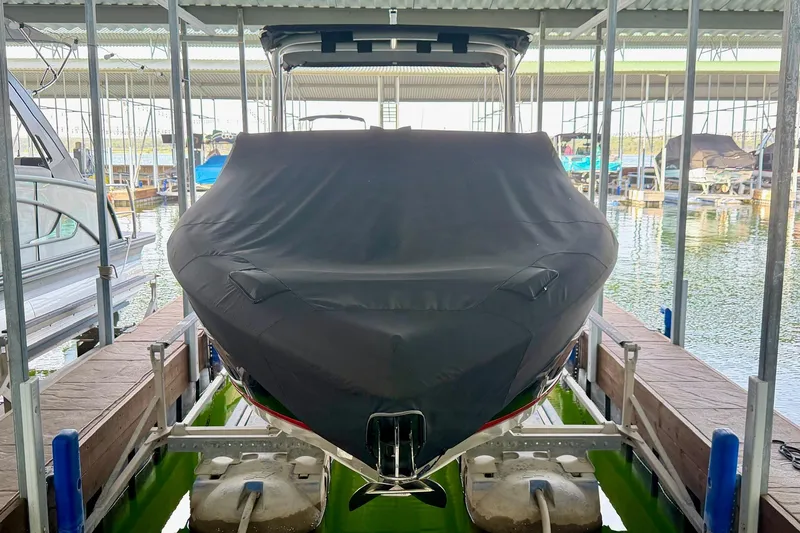 Slide: The Image of 2017 Cobalt A25 boat covered and docked in a marina. - 27