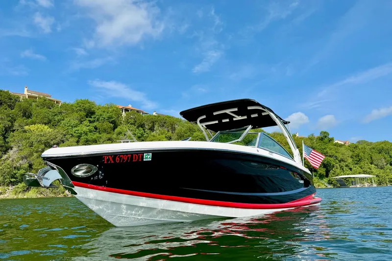 Slide: The Image of 2017 Cobalt A25 boat on water, American flag, lush green background. - 6
