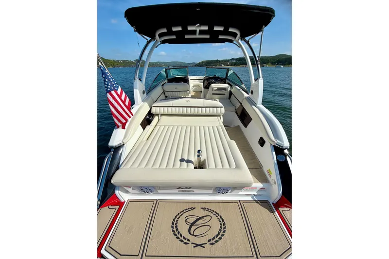 Slide: The Image of 2017 Cobalt A25 boat with sun deck, American flag, and scenic lake view. - 12