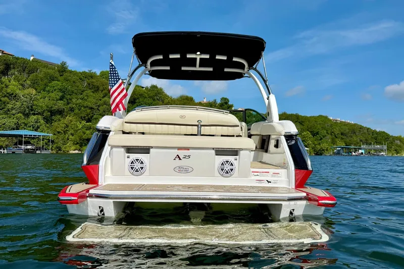Slide: The Image of 2017 Cobalt A25 boat on a lake, featuring a swim platform and American flag. - 8