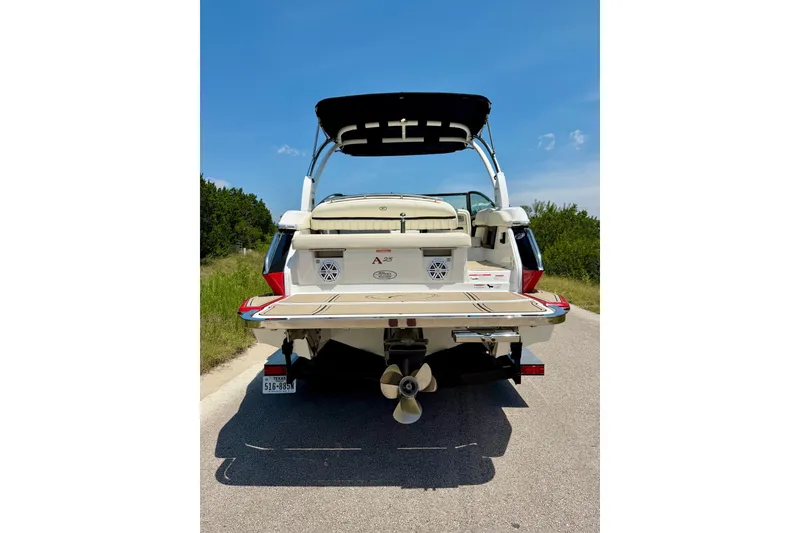 Slide: The Image of 2017 Cobalt A25 boat rear view on a sunny day, parked on a road. - 23