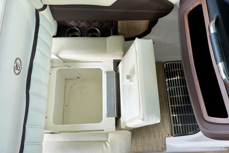 Slide: The Image of 2017 Cobalt A25 boat interior with open storage compartment and cup holders. - 41