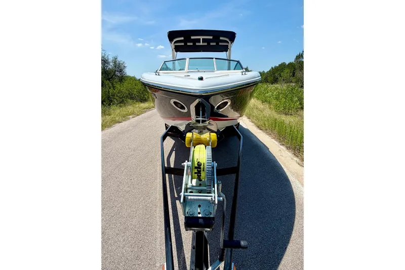 Slide: The Image of Front view of a 2017 Cobalt A25 boat on a trailer, parked on a road. - 22
