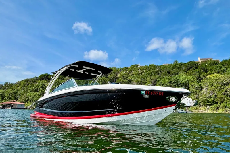 Slide: The Image of 2017 Cobalt A25 boat on water, black and white design, lush green background. - 3